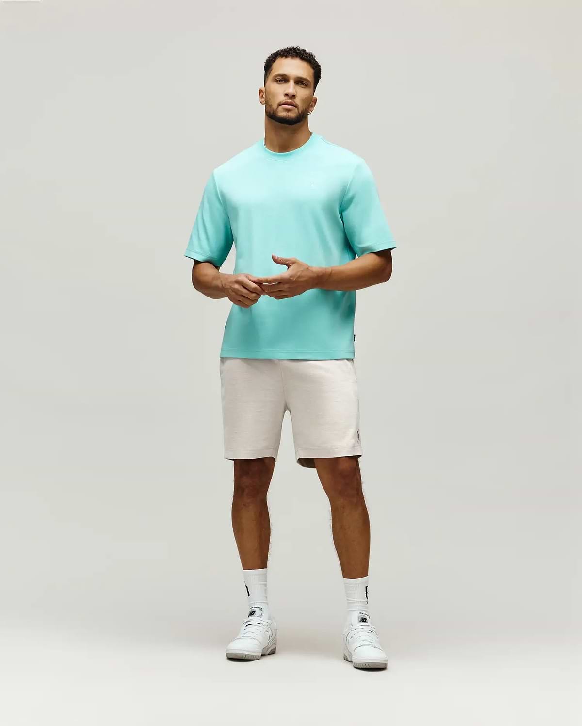 Mens Adam Interlock Tee in aqua, featuring a relaxed fit, smooth interlock knit, and a small tonal embroidered Psycho Bunny skull logo on the left chest, with a black brand tag on the side.