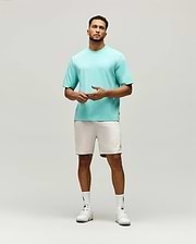 Mens Adam Interlock Tee in aqua, featuring a relaxed fit, smooth interlock knit, and a small tonal embroidered Psycho Bunny skull logo on the left chest, with a black brand tag on the side.