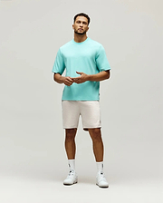 Mens Adam Interlock Tee in aqua, featuring a relaxed fit, smooth interlock knit, and a small tonal embroidered Psycho Bunny skull logo on the left chest, with a black brand tag on the side.