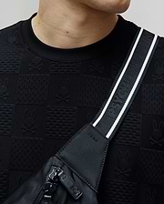 Mens Dustin Oversized Tee in black, featuring an all-over subtle jacquard checkerboard pattern with alternating Psycho Bunny skull logos and textured squares.