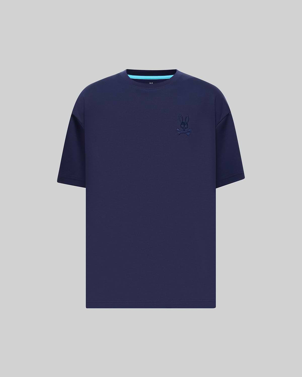 Mens Oscar Oversized Tee in navy blue jersey knit, featuring a relaxed fit, small embroidered Psycho Bunny skull logo on the left chest, and a light blue accent stripe on the inner collar.