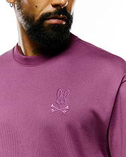 Mens Oscar Relaxed Fit Tee, a premium plum jersey knit t-shirt with a relaxed fit, featuring the iconic small tonal embroidered Psycho Bunny skull and crossbones logo on the left chest.