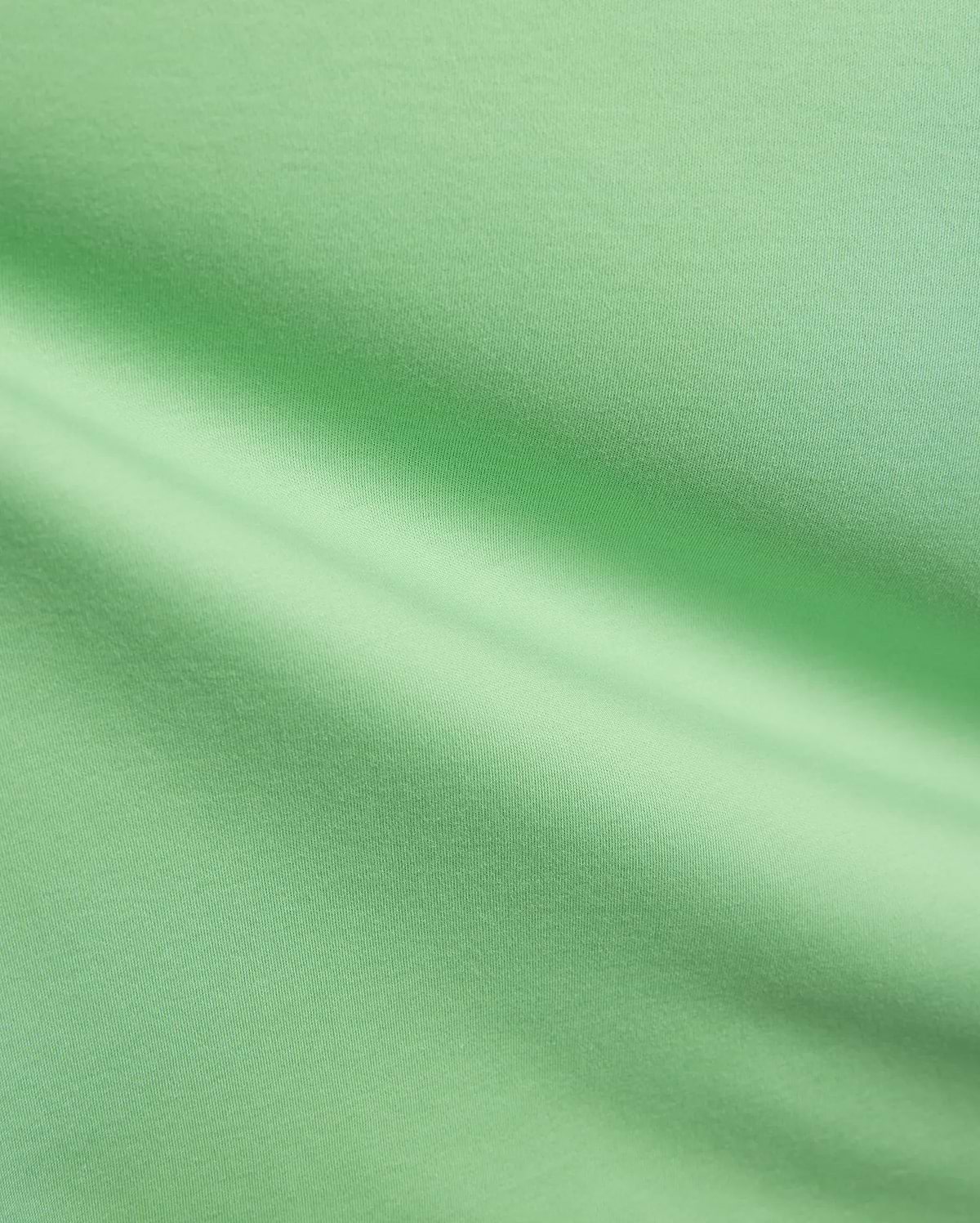 Mens Oscar Relaxed Fit Tee in a fresh, vibrant light green, premium soft jersey knit fabric, highlighting its smooth, breathable texture and elegant, relaxed drape with subtle folds and shadows.