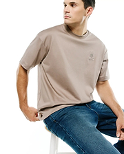 Men's Oscar Oversized Tee, a premium taupe jersey t-shirt with a relaxed fit, featuring a small, light grey embroidered Psycho Bunny skull logo on the left chest. (3)