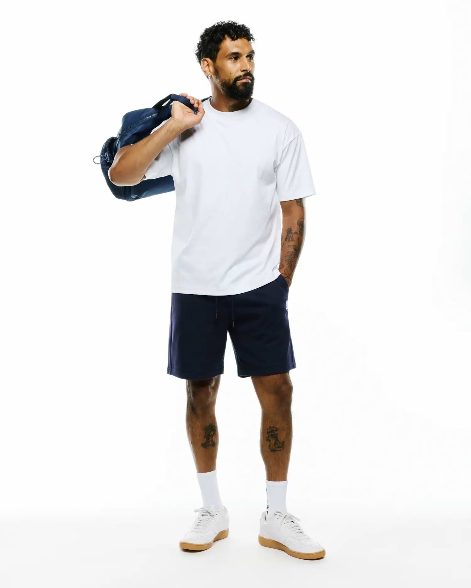 Mens Oscar Relaxed Fit Tee in white, a soft jersey crew neck with a relaxed fit. Paired with navy blue jersey shorts featuring a small white embroidered Psycho Bunny skull logo on the left leg.