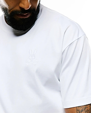 Mens Oscar Relaxed Fit Tee in white, featuring a relaxed fit and smooth jersey fabric. A small, tone-on-tone embroidered Psycho Bunny skull logo is on the left chest.