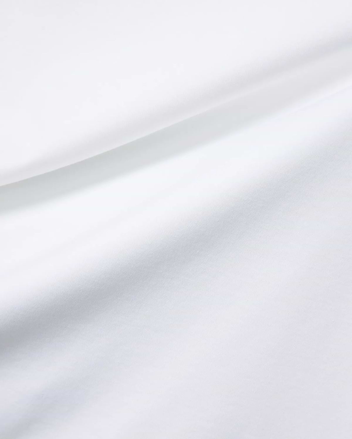 Mens Oscar Relaxed Fit Tee in premium, soft white jersey fabric, featuring subtle fabric folds and the signature small embroidered Psycho Bunny skull logo on the chest.