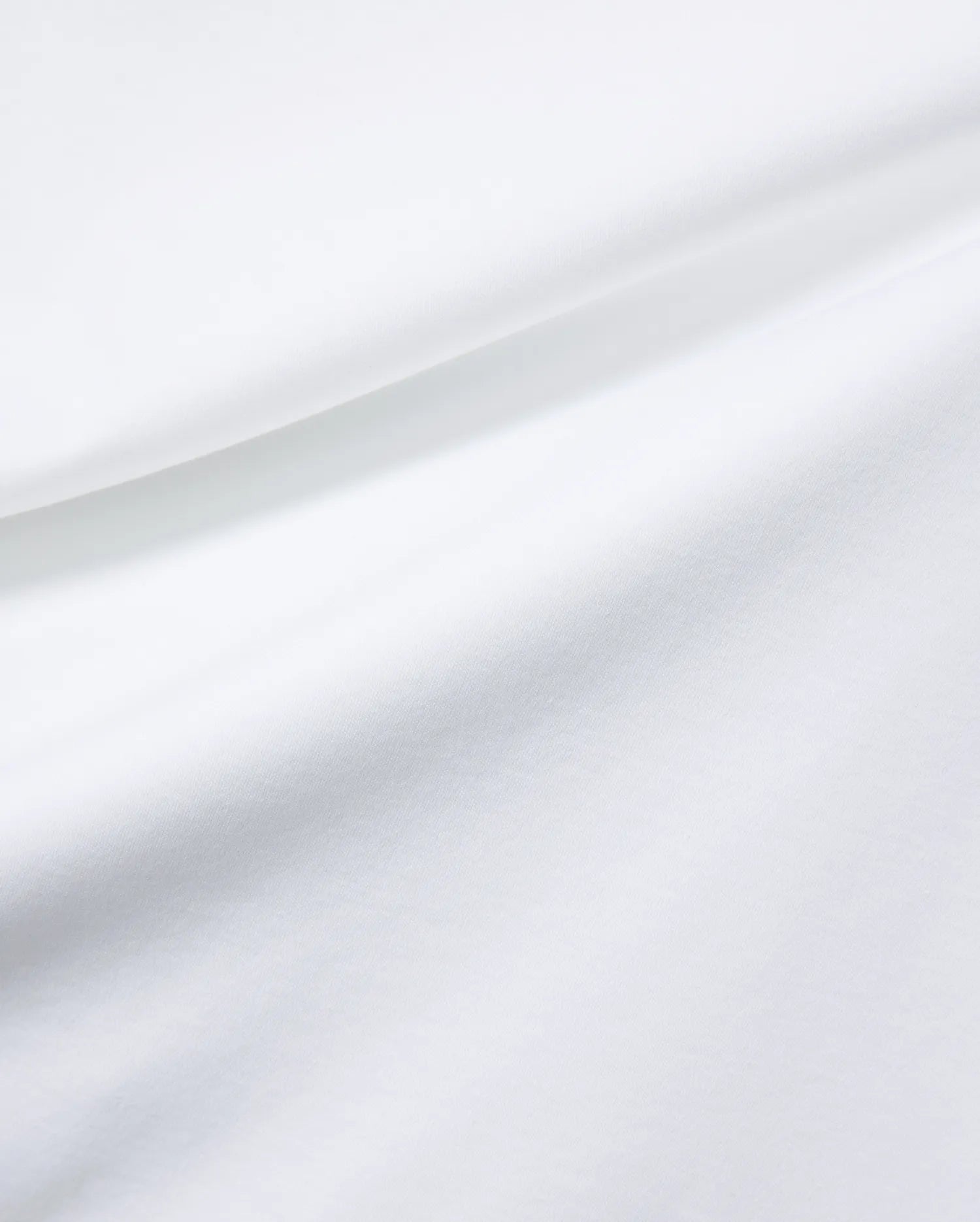 Mens Oscar Relaxed Fit Tee in premium, soft white jersey fabric, featuring subtle fabric folds and the signature small embroidered Psycho Bunny skull logo on the chest.