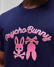 Mens Aram Graphic Tee in navy blue jersey, featuring a large, textured bright pink chest graphic with Psycho Bunny script, the iconic bunny skull, and crossed bones design for a classic fit.