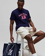Mens Aram Graphic Tee in navy, featuring a classic fit and smooth jersey fabric. A large pink Psycho Bunny script and bunny skull graphic are prominently displayed on the center chest.