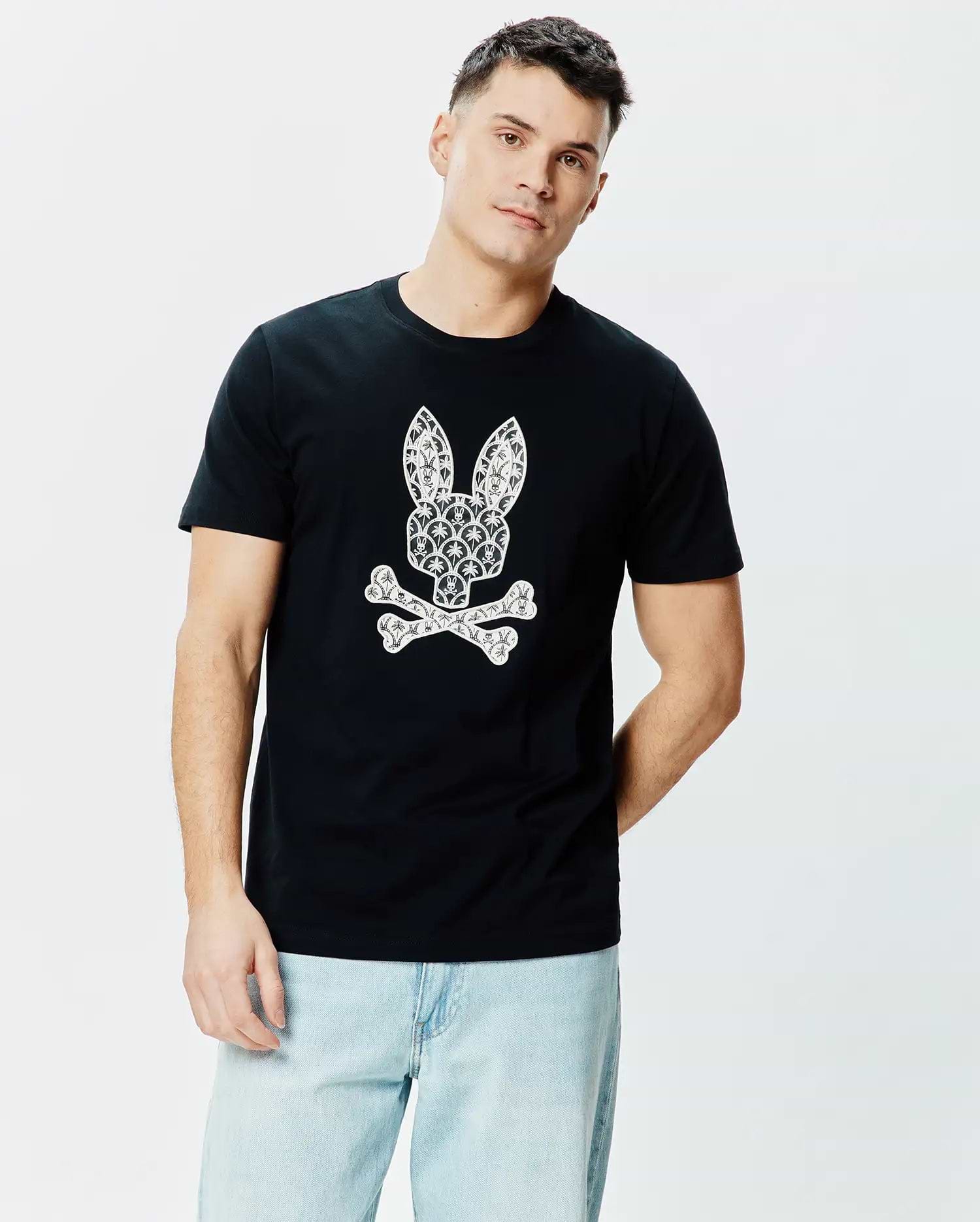 Black Mens Brad Graphic Tee, a classic fit jersey t-shirt with a large, centered white Psycho Bunny skull logo intricately patterned with small palm trees and motifs.