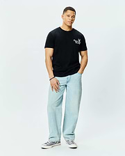 Mens Colin Back Graphic Tee, a black classic fit jersey t-shirt, features a small white embroidered Psycho Bunny skull logo and text on the left chest.