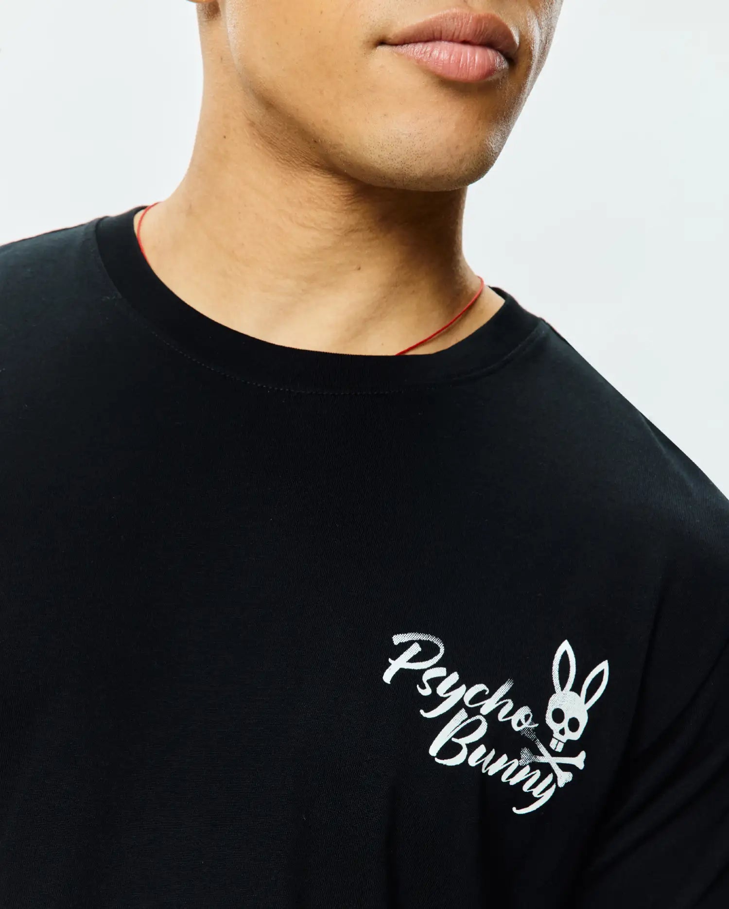 Black Mens Colin Back Graphic Tee, classic fit, smooth jersey knit, featuring a small white printed Psycho Bunny skull and crossbones logo with script on the left chest.