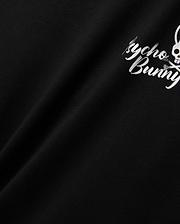 Mens Colin Back Graphic Tee in black, crafted from smooth jersey knit, showcasing a bold white Psycho Bunny script and iconic bunny skull logo graphic on the back.