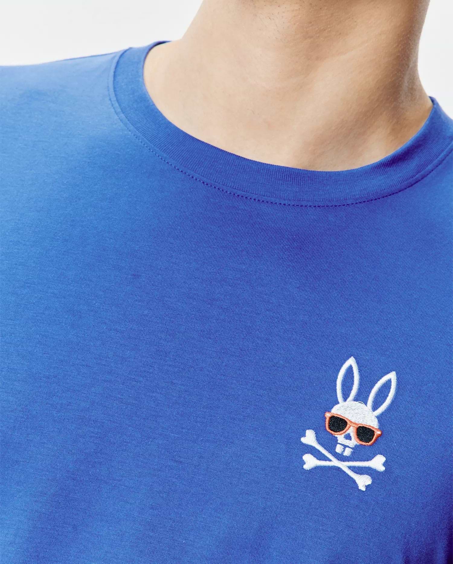 Royal blue classic fit jersey knit T-shirt featuring a small, embroidered Psycho Bunny skull logo with orange sunglasses and white crossbones on the left chest. Mens Sunny Chest Graphic Tee.