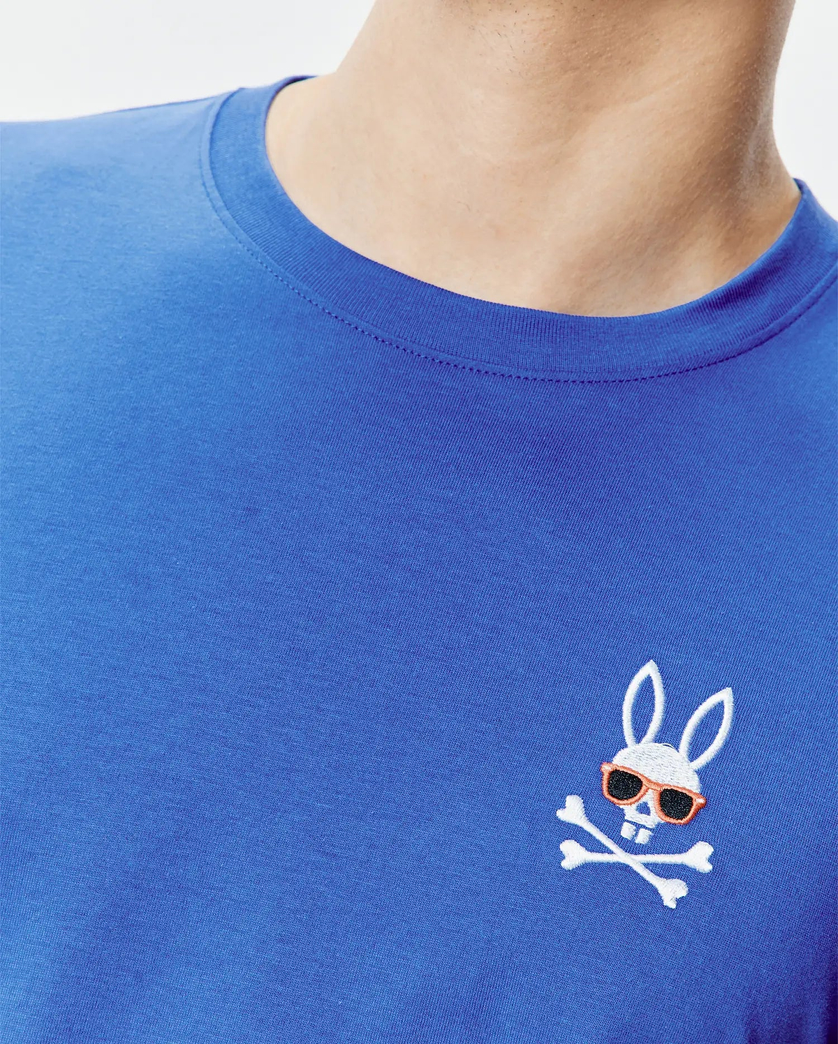 Royal blue classic fit jersey knit T-shirt featuring a small, embroidered Psycho Bunny skull logo with orange sunglasses and white crossbones on the left chest. Mens Sunny Chest Graphic Tee.