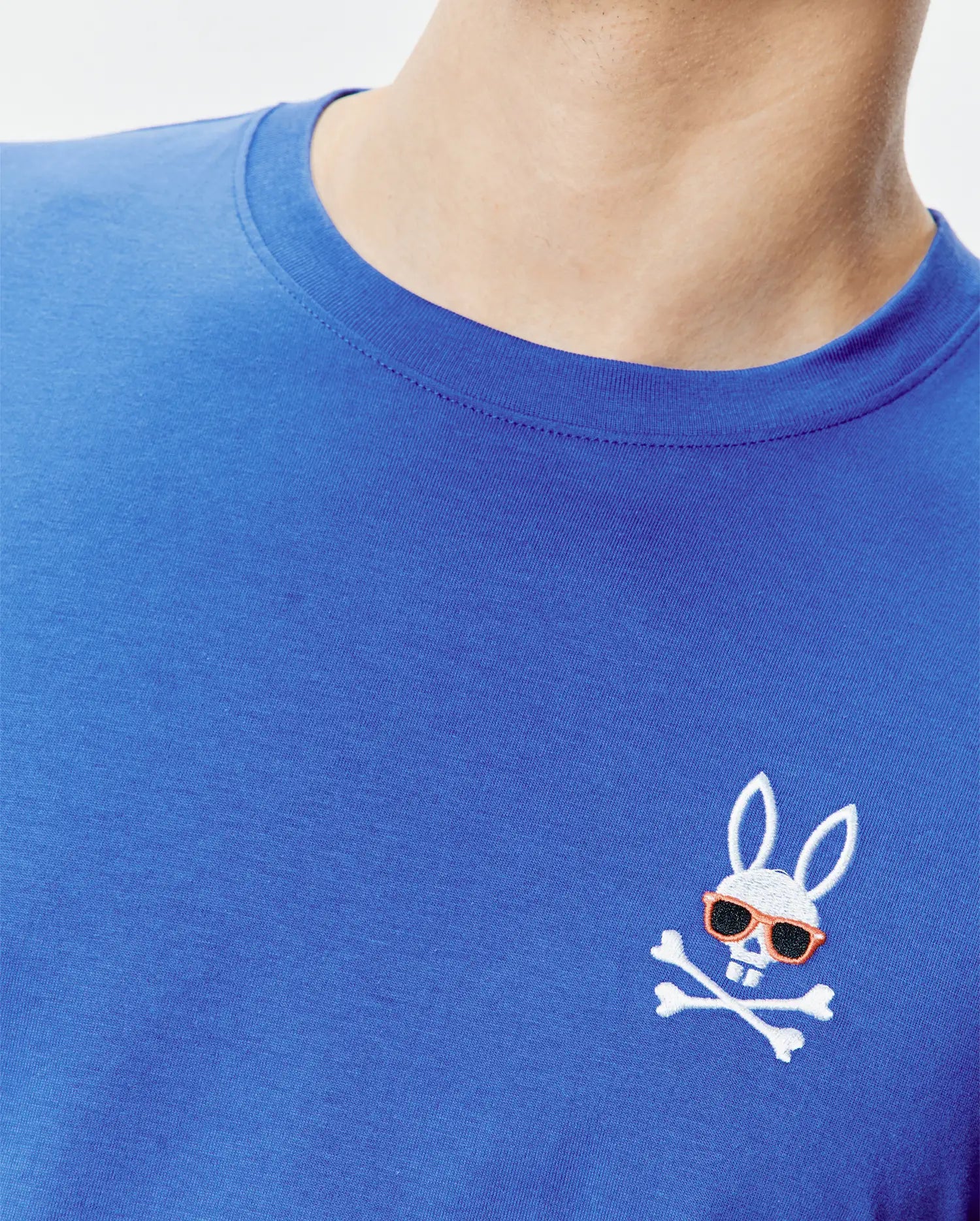 Royal blue classic fit jersey knit T-shirt featuring a small, embroidered Psycho Bunny skull logo with orange sunglasses and white crossbones on the left chest. Mens Sunny Chest Graphic Tee.