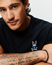 Black classic fit Sunny Chest Graphic Tee in smooth jersey knit, featuring an embroidered Psycho Bunny skull with blue sunglasses and white crossbones on the left chest.