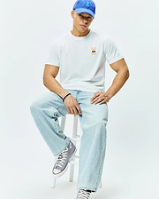 White Mens Sunny Chest Graphic Tee, classic fit, smooth jersey knit, featuring a small embroidered orange and black Psycho Bunny skull with blue sunglasses logo on the left chest.