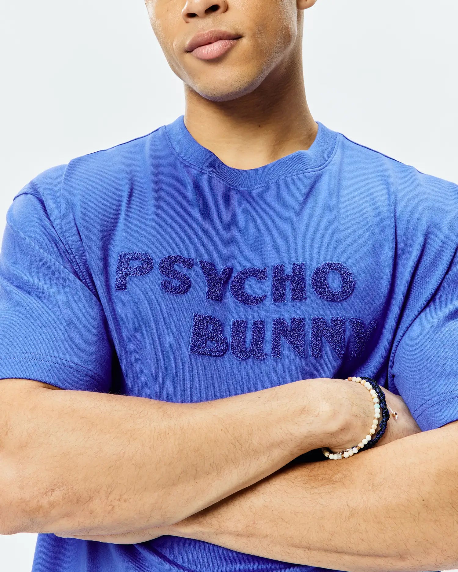 Royal blue Mens Craig Wordmark Tee, a classic fit jersey knit t-shirt with a large, textured, embossed PSYCHO BUNNY wordmark across the chest.