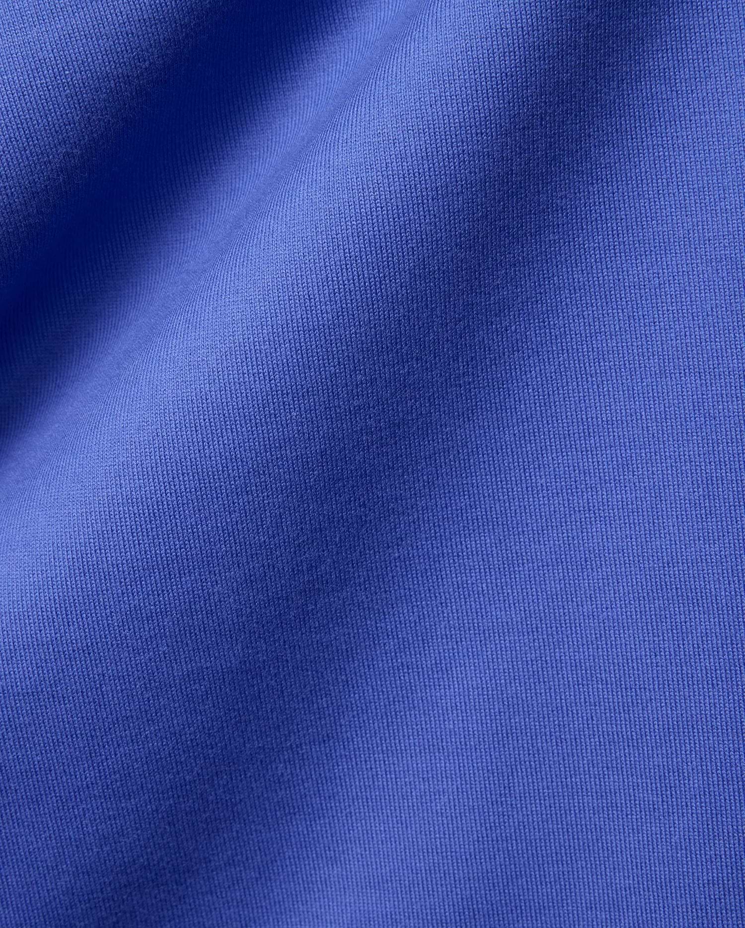 Mens Craig Wordmark Tee crafted from a premium, vibrant blue jersey knit fabric, showcasing a smooth texture with subtle vertical ribbing and elegant, soft folds.