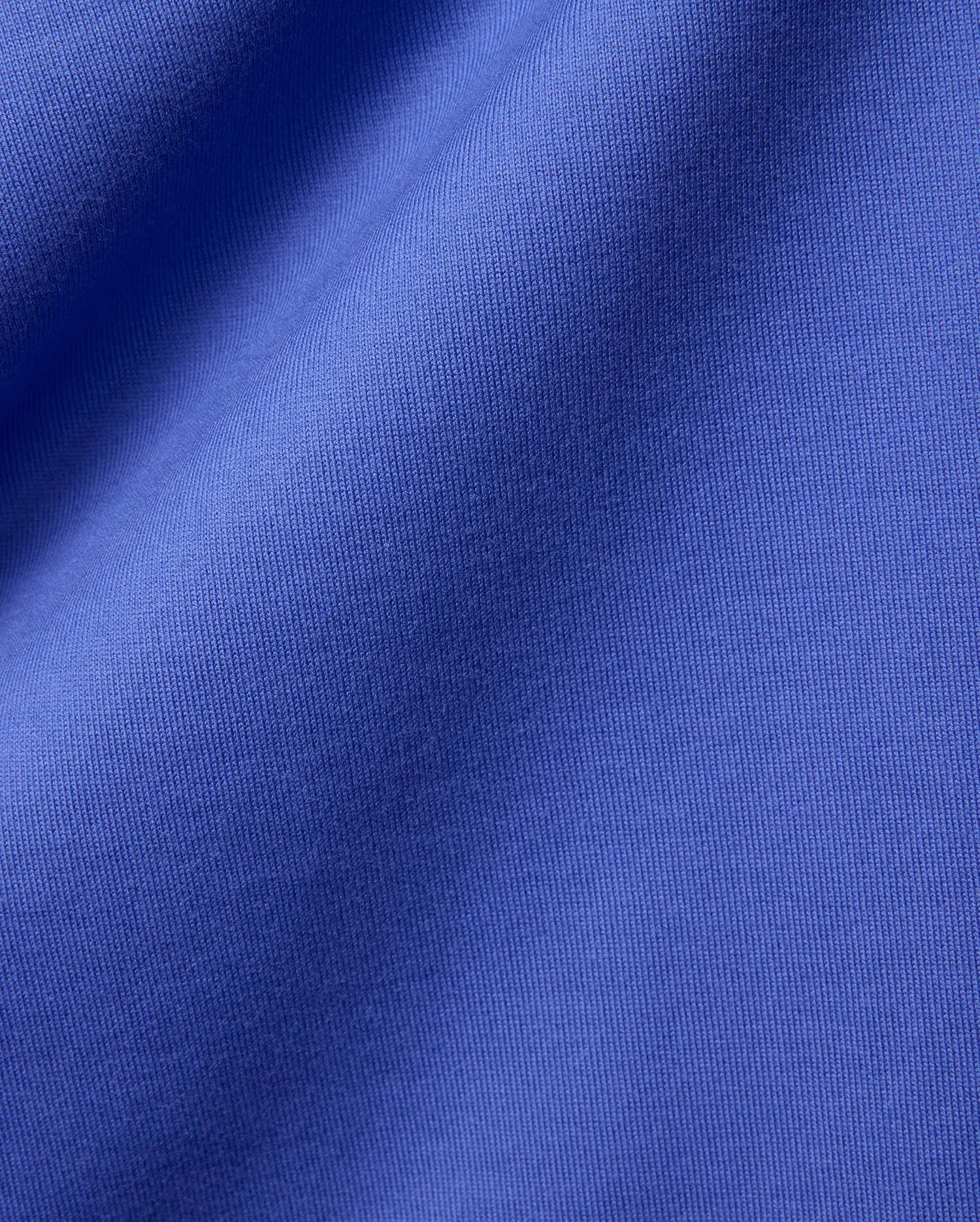 Mens Craig Wordmark Tee crafted from a premium, vibrant blue jersey knit fabric, showcasing a smooth texture with subtle vertical ribbing and elegant, soft folds.