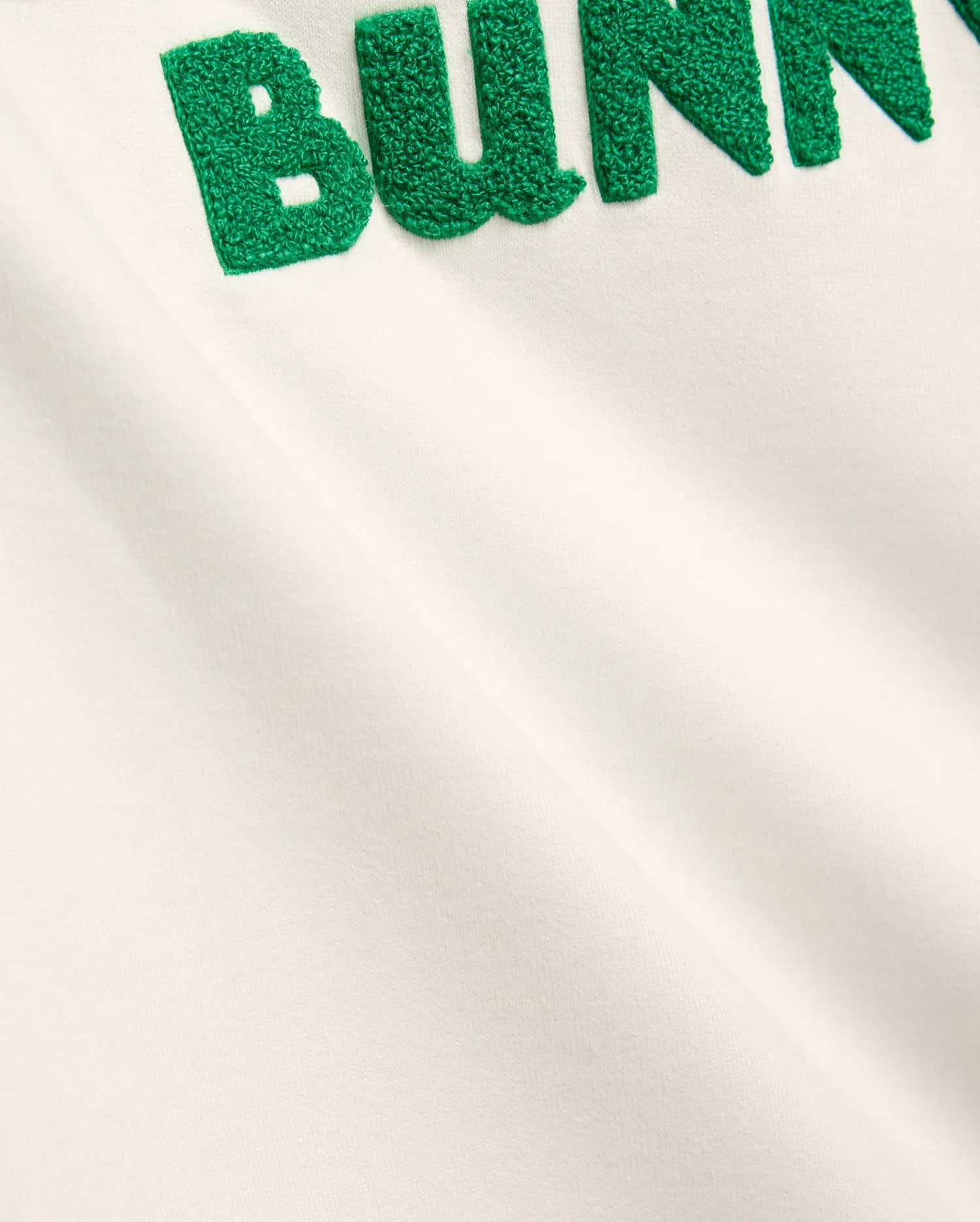 Mens Craig Wordmark Tee in soft off-white jersey, showcasing a bold, large green textured chenille BUNNY wordmark prominently embroidered on the chest, embodying refined streetwear.