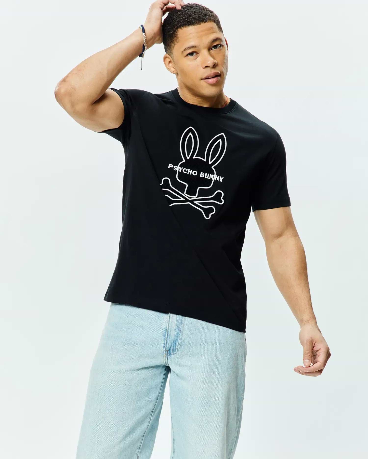 Mens Craig Graphic Tee, black classic fit jersey knit with a large white Psycho Bunny skull and crossbones logo and text graphic prominently displayed on the chest.