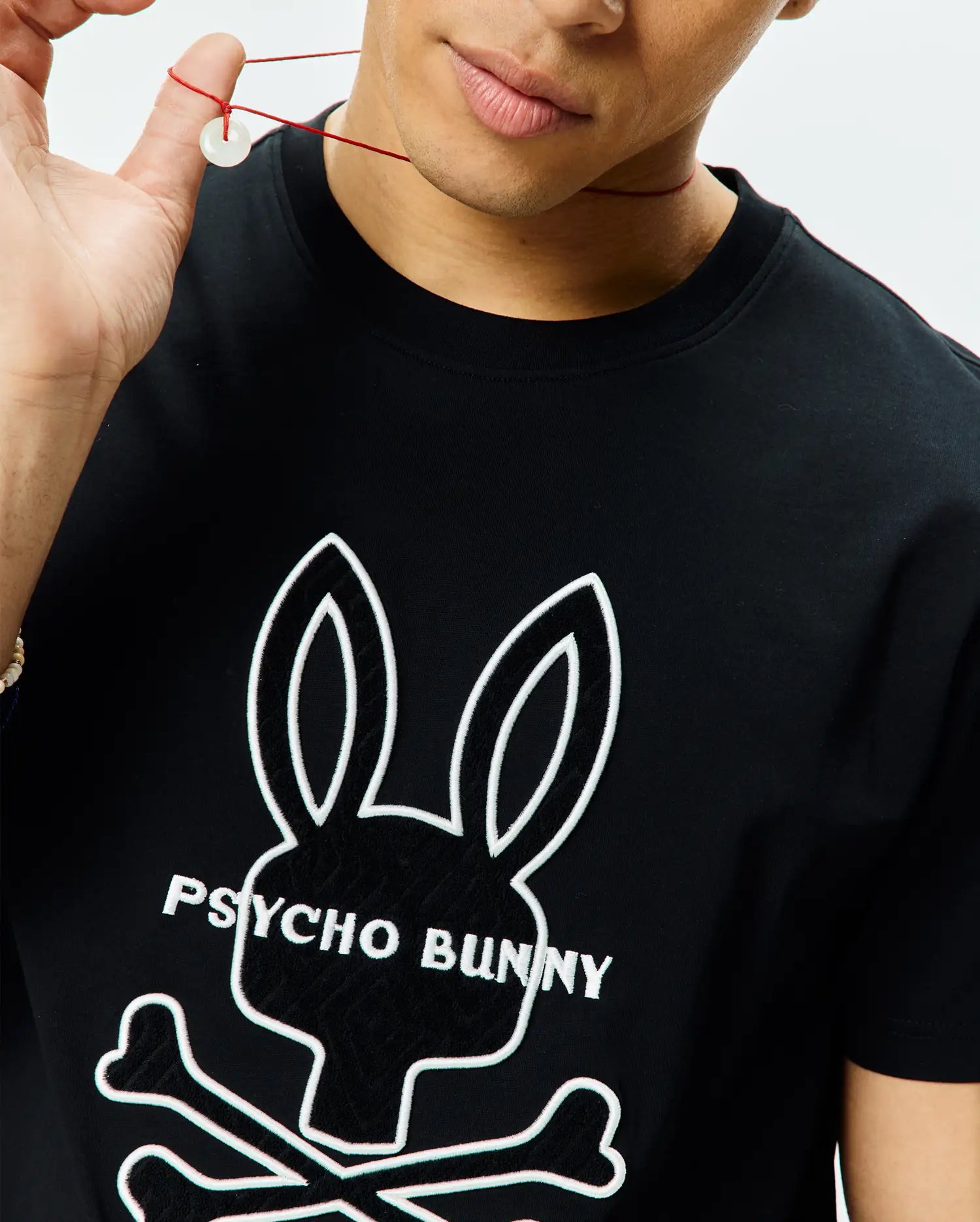 Black Mens Craig Graphic Tee in soft jersey knit, classic fit, featuring a large central white outline of the iconic Psycho Bunny skull logo with black fill and Psycho Bunny text.