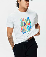 Mens Tanner Graphic Tee, a classic fit white jersey t-shirt featuring a large, vibrant multi-color graphic print of stacked Psycho Bunny skull logos and crossbones on the chest.