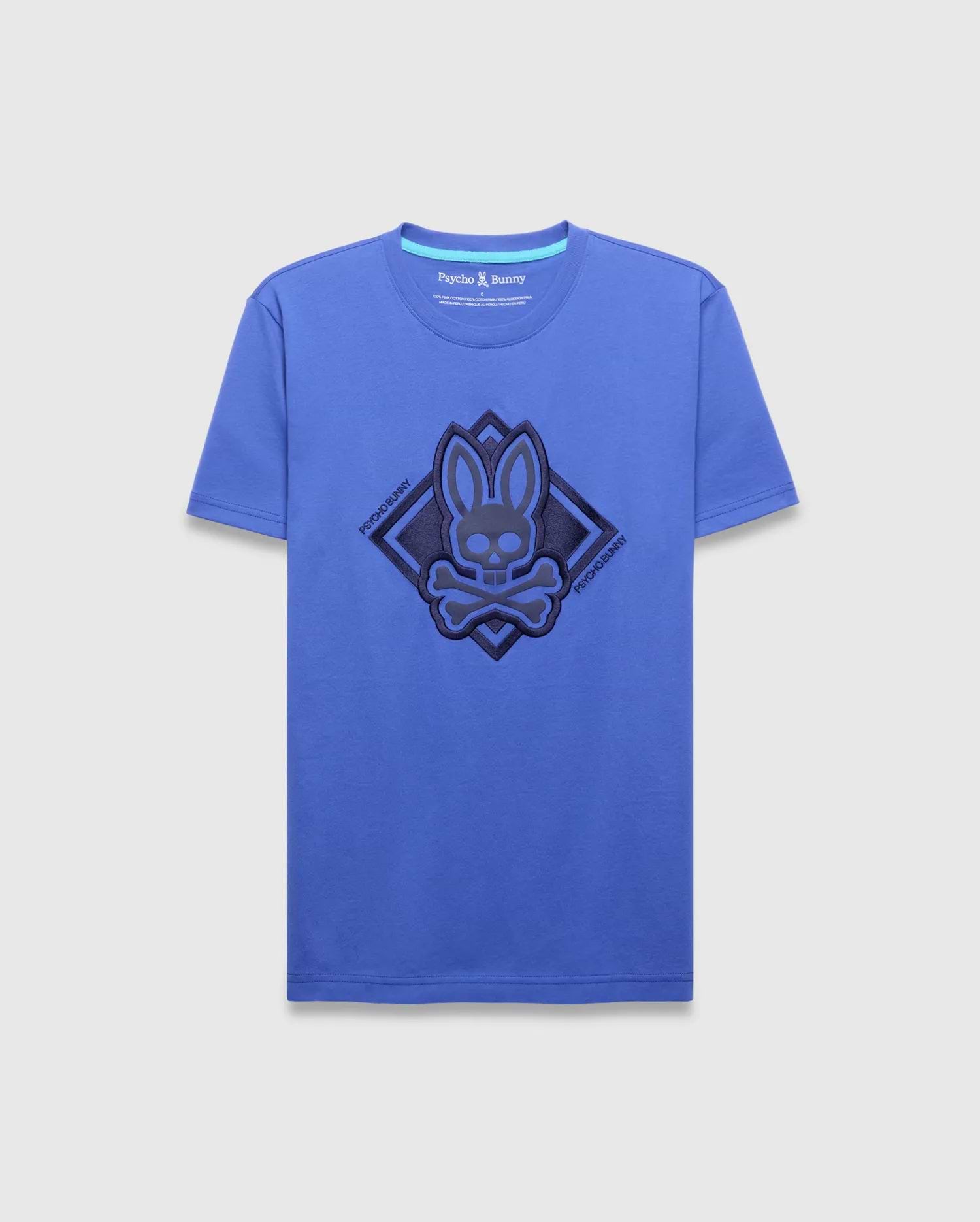 Mens Tobias Graphic Tee, royal blue classic fit jersey t-shirt featuring a large central dark blue textured bunny skull logo within a diamond outline, flanked by diagonal Psycho Bunny text.