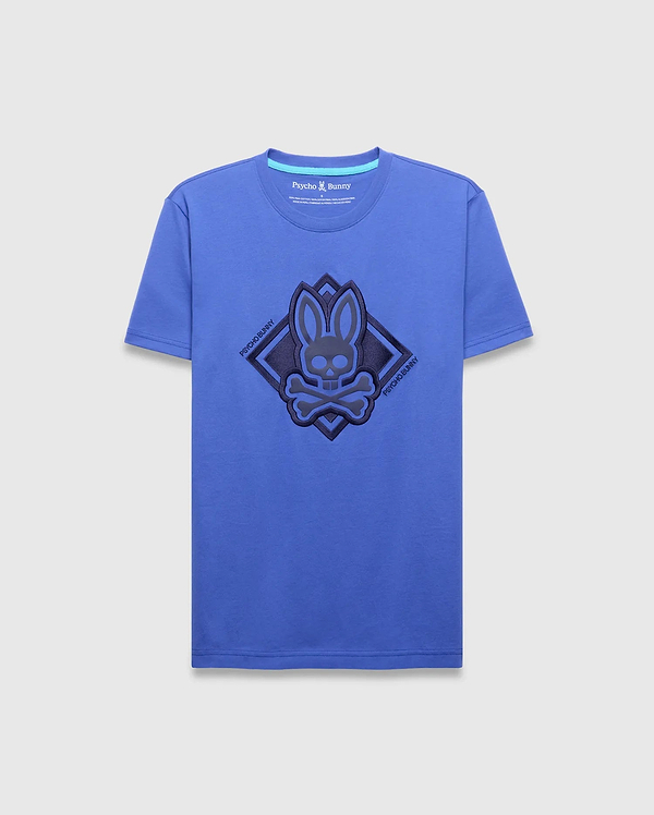 Mens Tobias Graphic Tee, royal blue classic fit jersey t-shirt featuring a large central dark blue textured bunny skull logo within a diamond outline, flanked by diagonal Psycho Bunny text.