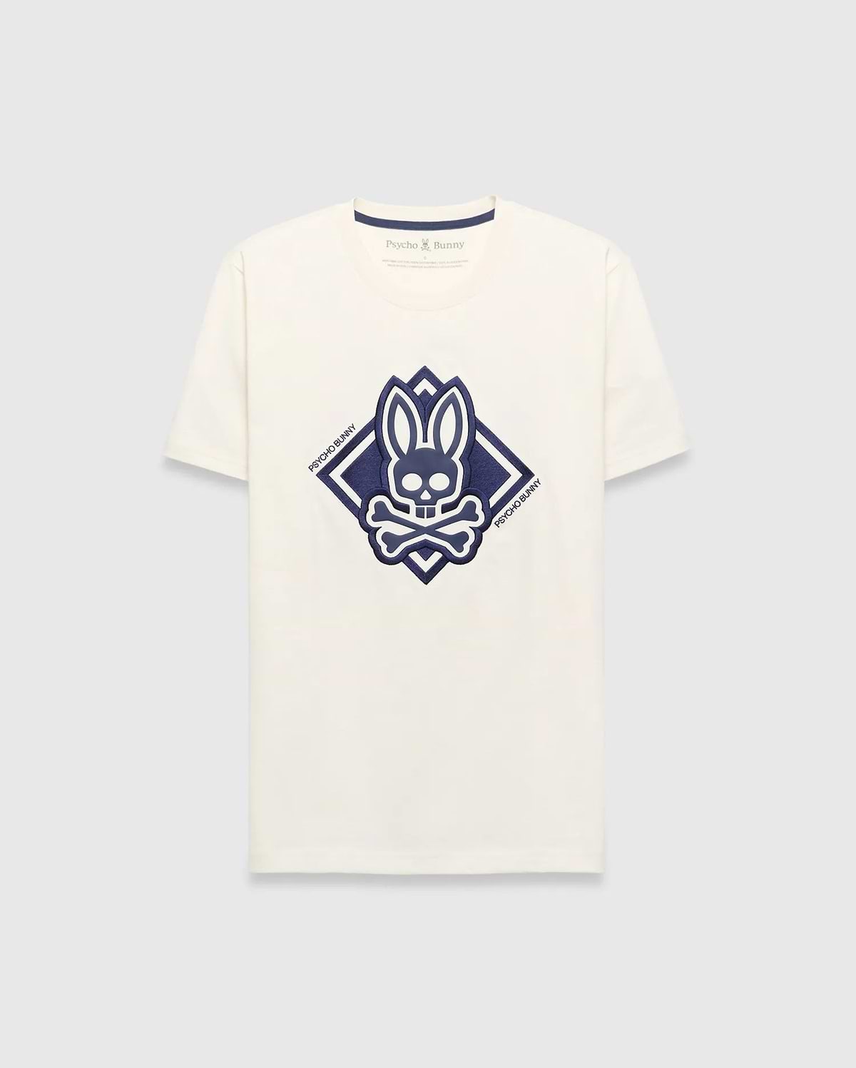 Mens Tobias Graphic Tee, a cream classic fit jersey t-shirt with a large central navy blue Psycho Bunny skull and crossbones logo inside a diamond graphic, featuring Psycho Bunny text.