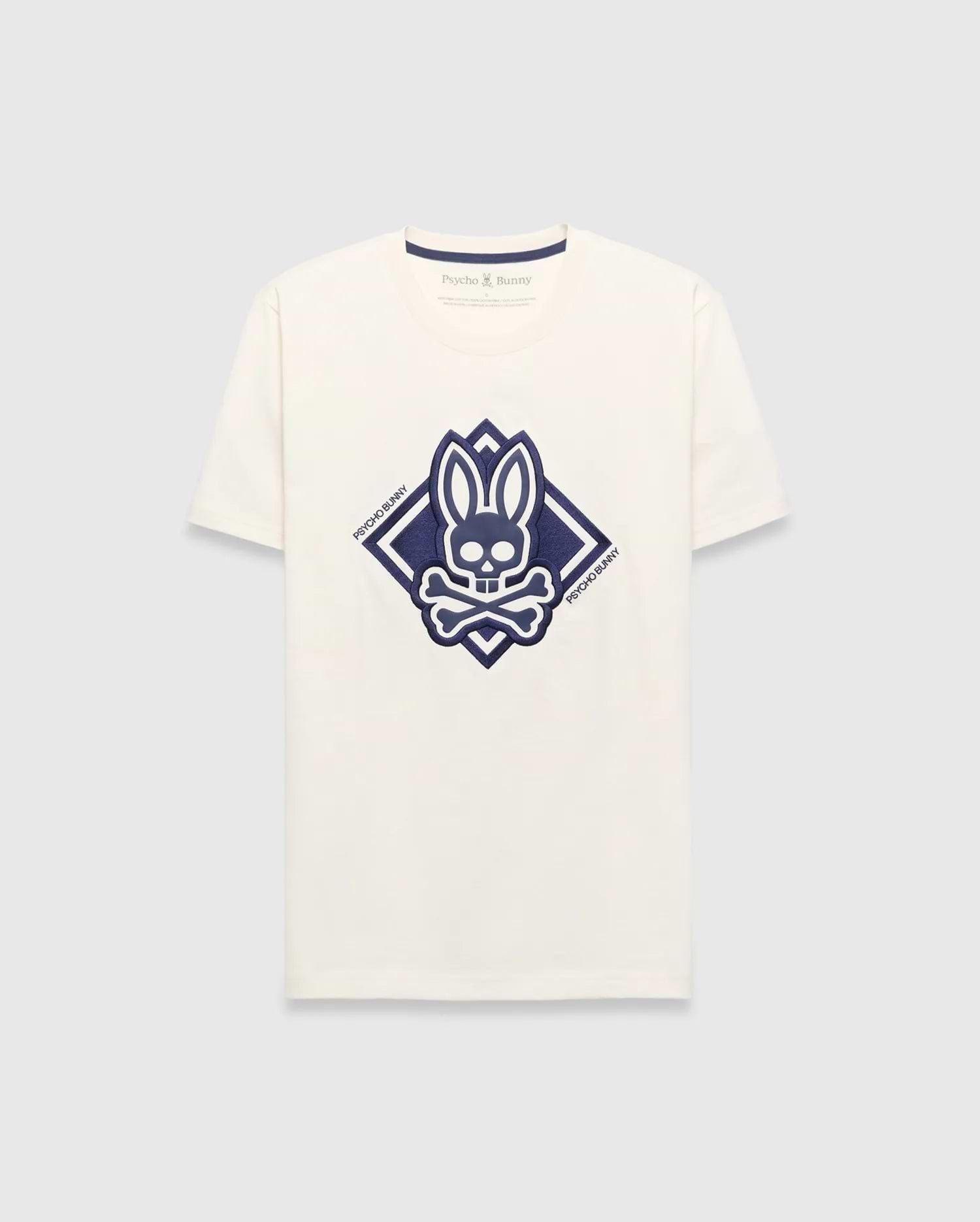 Mens Tobias Graphic Tee, a cream classic fit jersey t-shirt with a large central navy blue Psycho Bunny skull and crossbones logo inside a diamond graphic, featuring Psycho Bunny text.