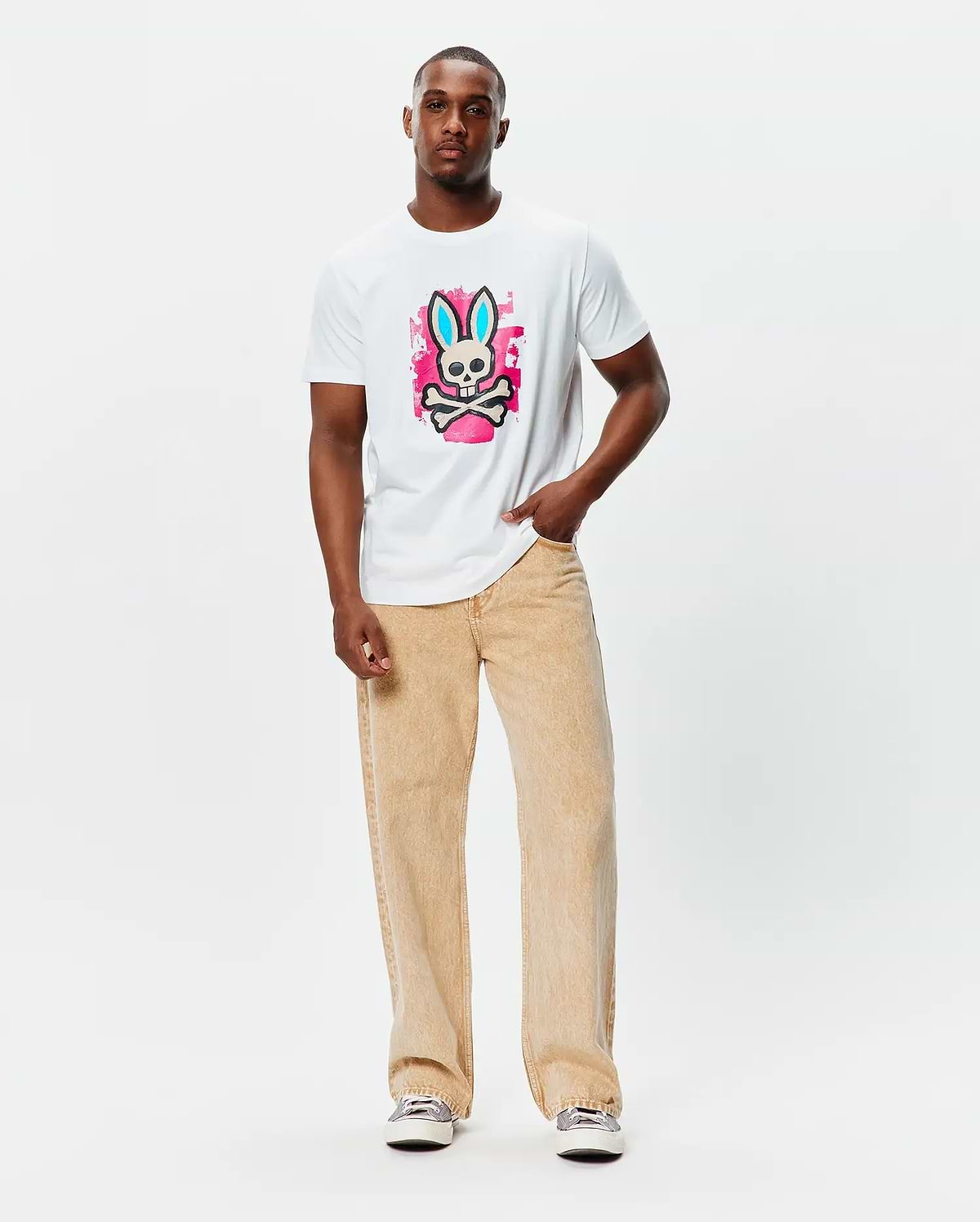 Mens Marcus Bunny Graphic Tee, a classic fit white jersey t-shirt featuring a large central graphic of the Psycho Bunny skull with blue ears on a vibrant pink paint splatter background.