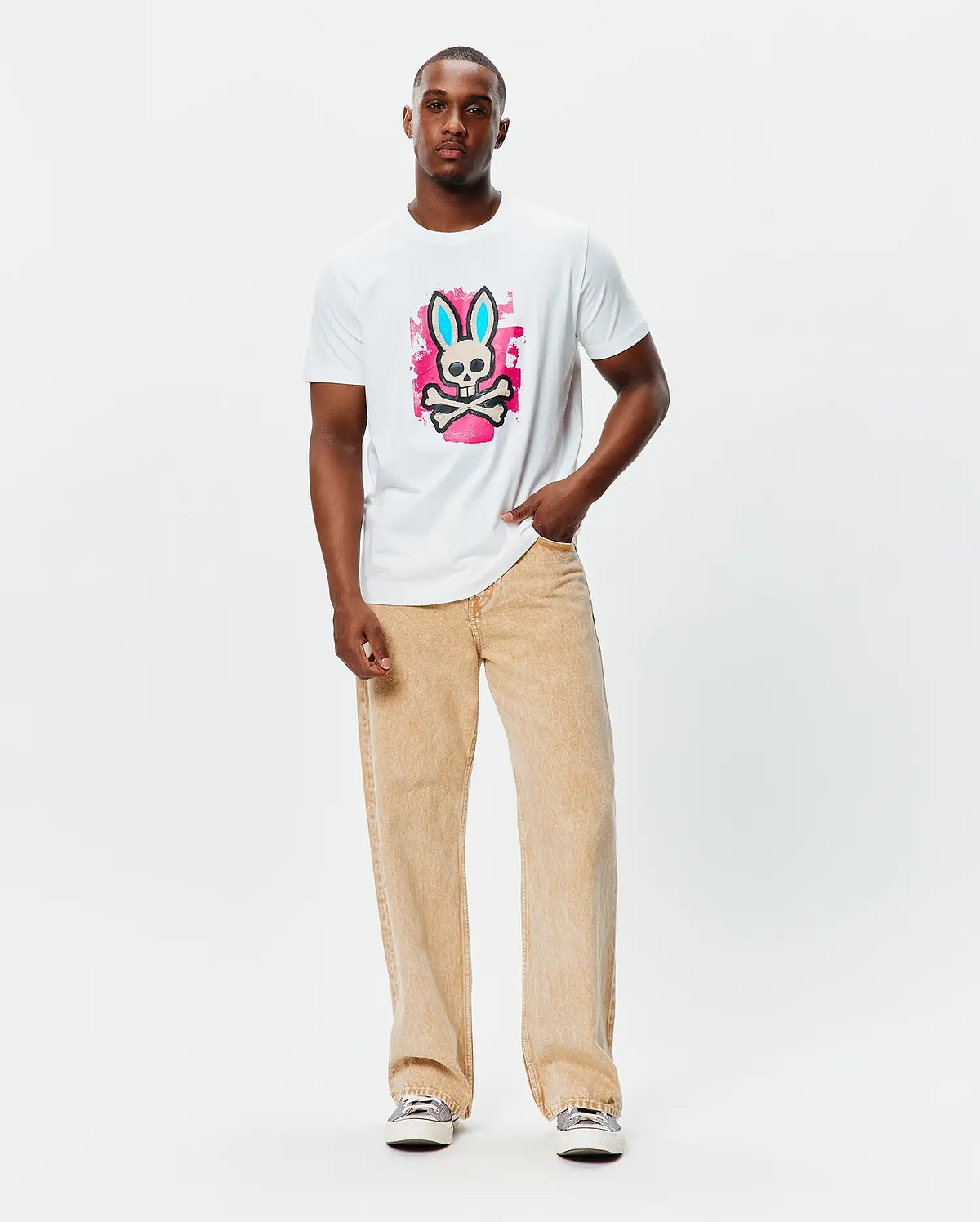 Mens Marcus Bunny Graphic Tee, a classic fit white jersey t-shirt featuring a large central graphic of the Psycho Bunny skull with blue ears on a vibrant pink paint splatter background.