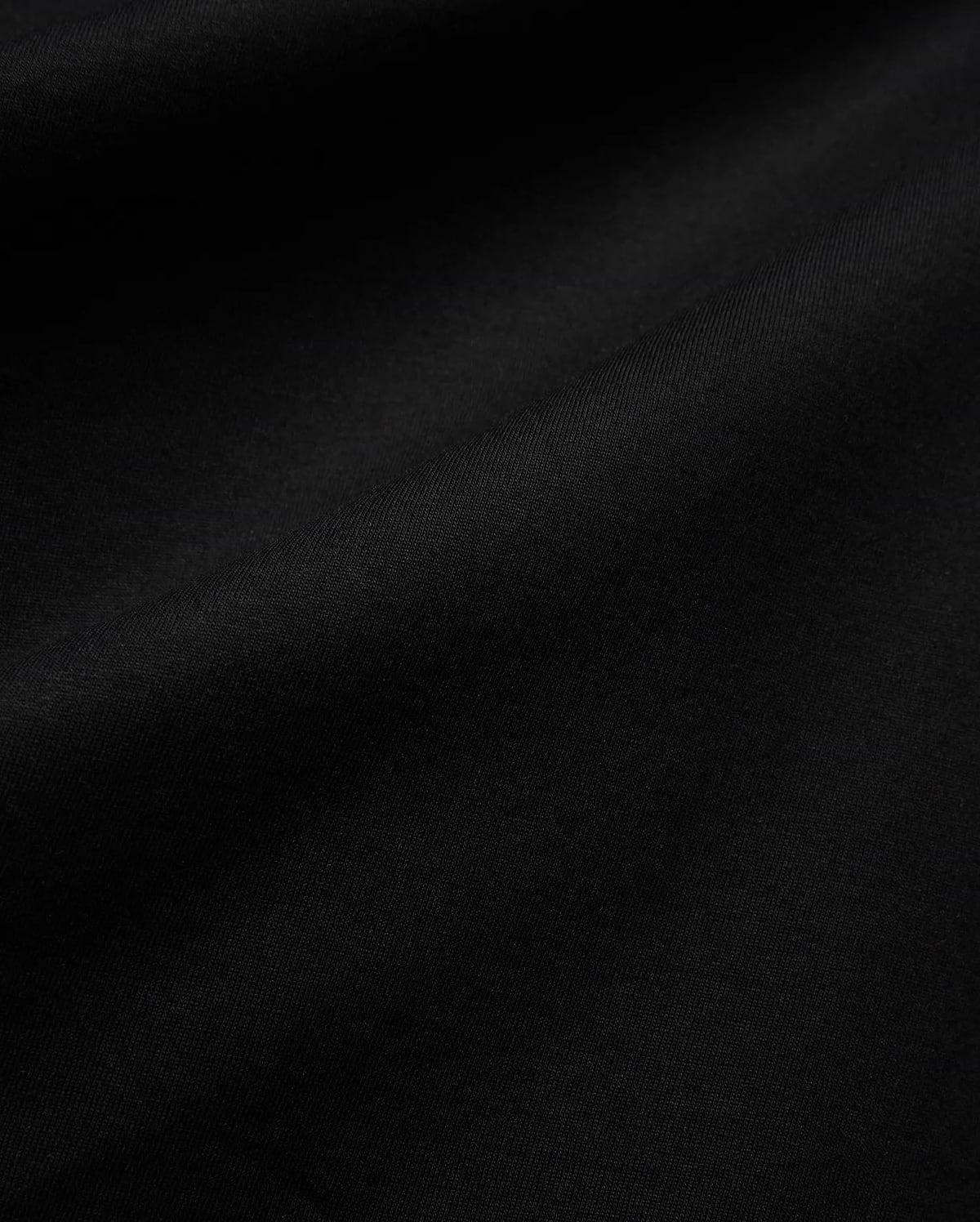 Mens Isaac Relaxed Fit Tee, a premium Psycho Bunny black jersey knit fabric, showcasing its soft, smooth texture with subtle, elegant folds, ideal for refined streetwear.
