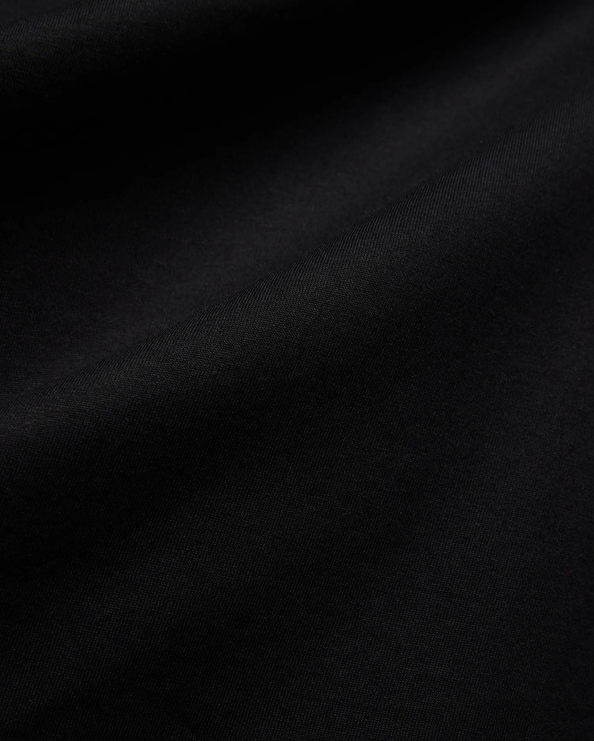 Mens Isaac Relaxed Fit Tee, a premium Psycho Bunny black jersey knit fabric, showcasing its soft, smooth texture with subtle, elegant folds, ideal for refined streetwear.