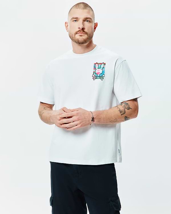 White Mens Isaac Relaxed Fit Tee, crafted from soft jersey, features a prominent multi-color Psycho Bunny skull logo graphic print on the left chest.