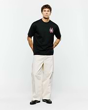 Mens Duncan Relaxed Fit Tee, a black relaxed fit jersey tee featuring a vibrant pink embroidered Psycho Bunny skull logo and text on the left chest.