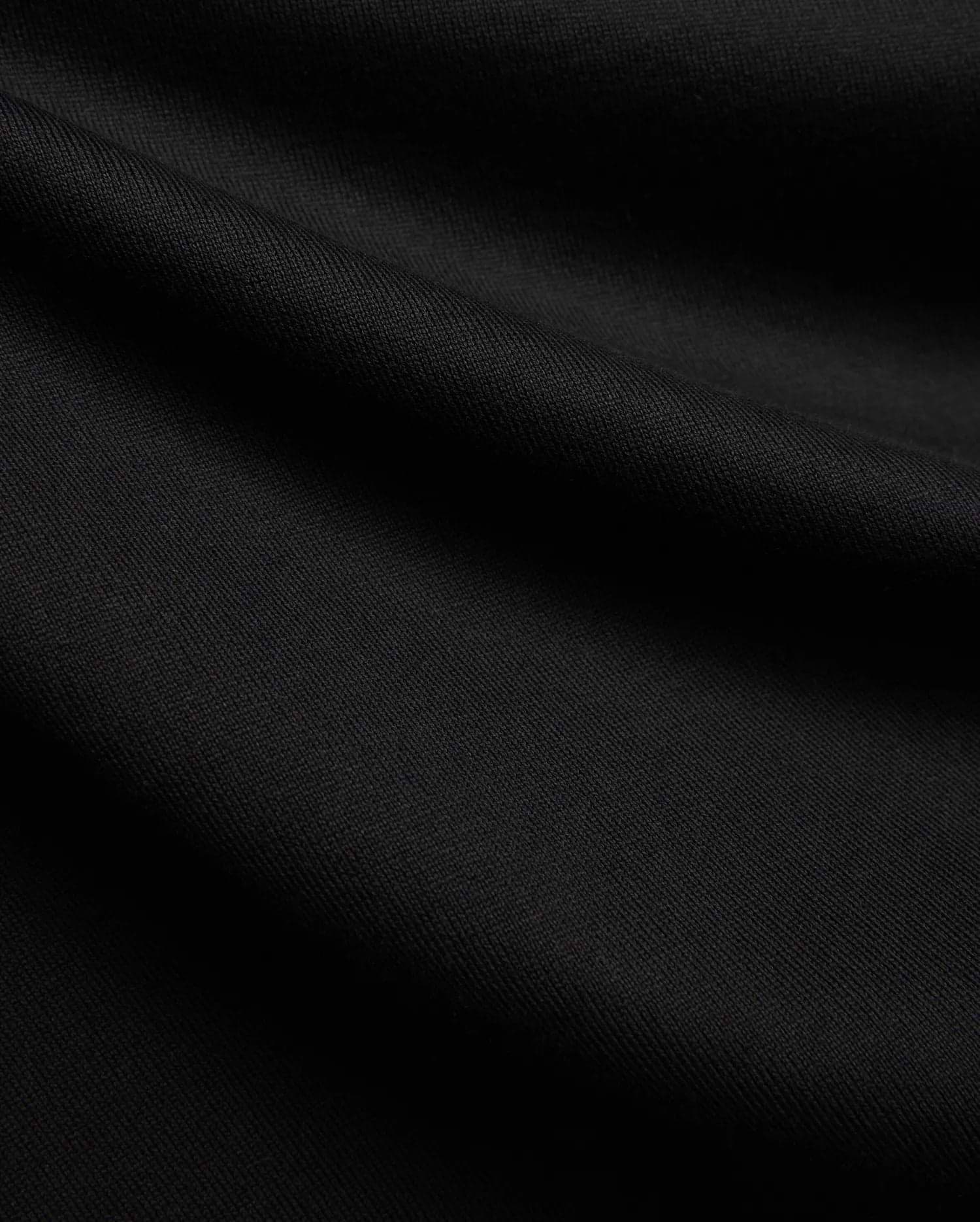 Black MENS DUNCAN RELAXED FIT TEE, a soft, premium jersey knit fabric with subtle folds, emphasizing its comfortable relaxed fit.