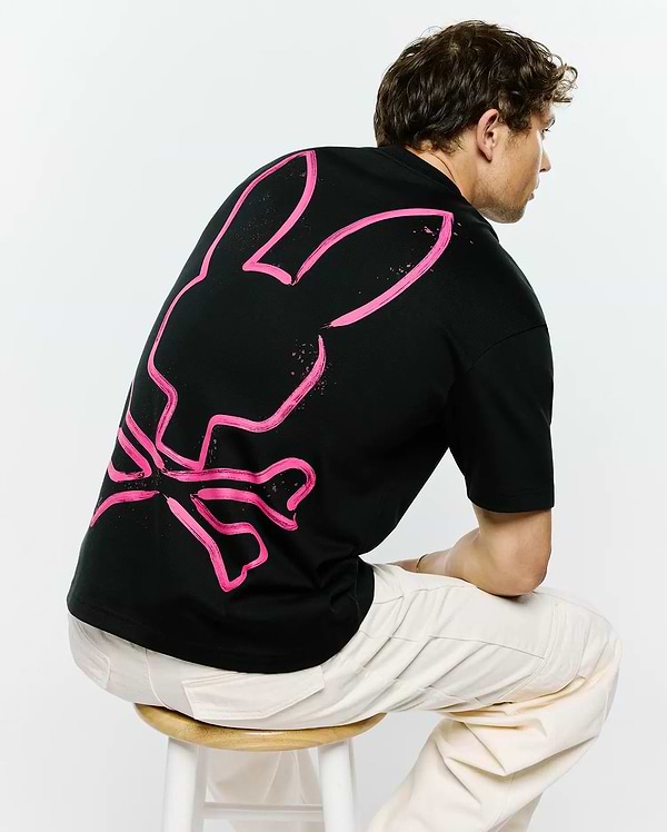 Mens Duncan Wordmark Relaxed Fit Tee, black jersey knit t-shirt with a large, vibrant pink brushstroke Psycho Bunny skull logo graphic on the back.