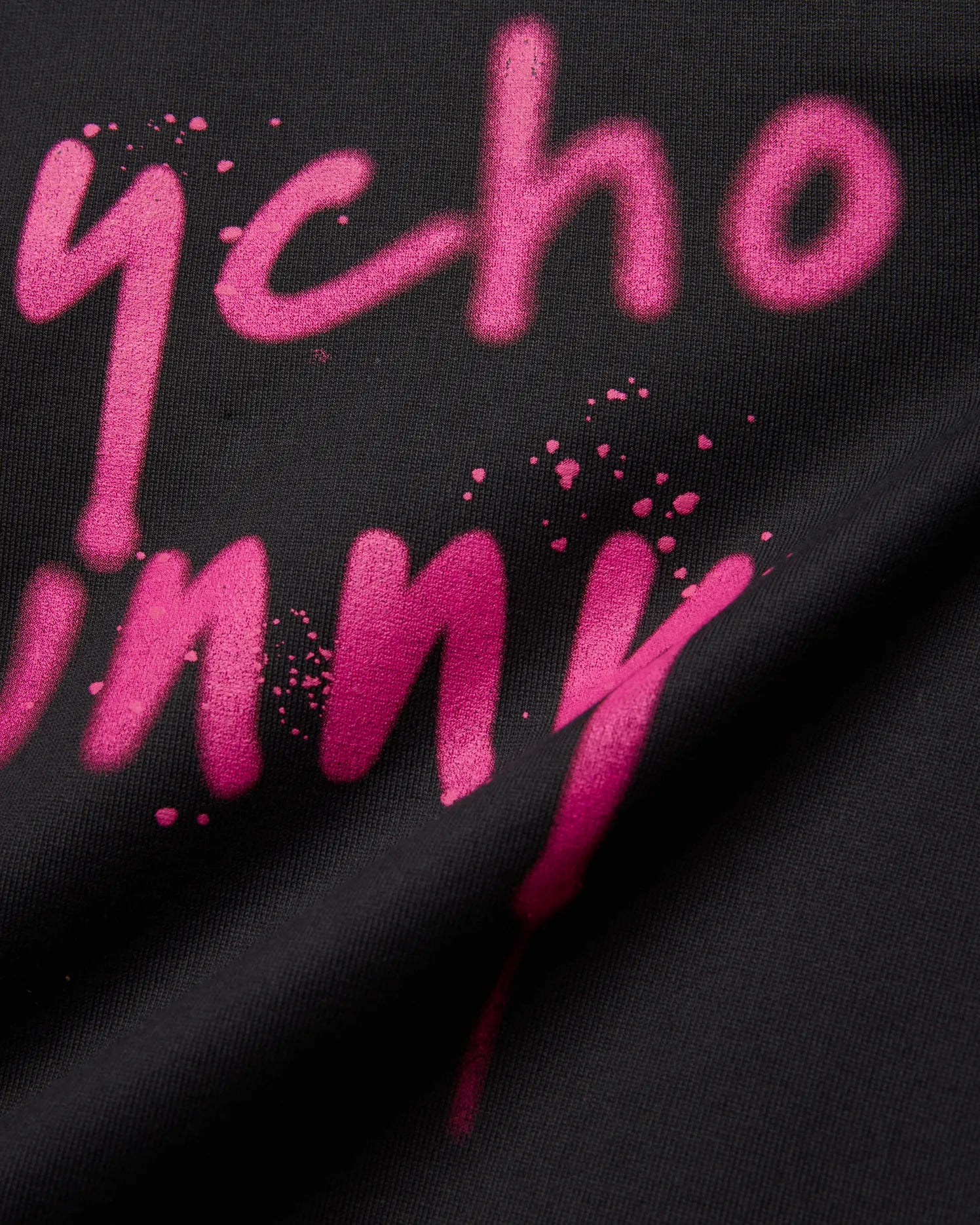 Mens Duncan Wordmark Relaxed Fit Tee, black with a vibrant pink spray paint style Psycho Bunny wordmark graphic featuring paint splatters and a soft jersey texture.
