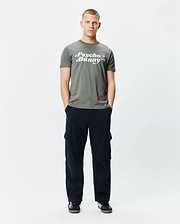 Mens Byron Wordmark Tee, a classic fit olive green jersey t-shirt with a large white Psycho Bunny wordmark graphic and blue-eyed skull logo on the chest.