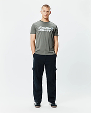 Mens Byron Wordmark Tee, a classic fit olive green jersey t-shirt with a large white Psycho Bunny wordmark graphic and blue-eyed skull logo on the chest.