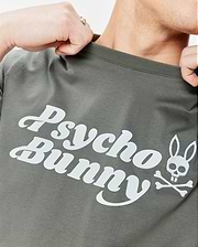 Mens Byron Wordmark Tee in dark olive green, a classic fit soft jersey knit t-shirt featuring a large white Psycho Bunny wordmark and embroidered bunny skull with crossbones graphic on the chest.