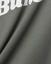 Mens Byron Wordmark Tee in dark olive green, crafted from soft jersey knit fabric. Features a prominent, large white wordmark graphic, with the letters Bu clearly visible, embodying the iconic Psycho Bunny brand.