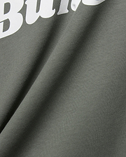 Mens Byron Wordmark Tee in dark olive green, crafted from soft jersey knit fabric. Features a prominent, large white wordmark graphic, with the letters Bu clearly visible, embodying the iconic Psycho Bunny brand.