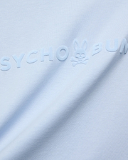 Mens Royce Graphic Tee, light blue jersey knit, featuring a large, tonal, raised velvety Psycho Bunny text logo with the iconic bunny skull on the chest.