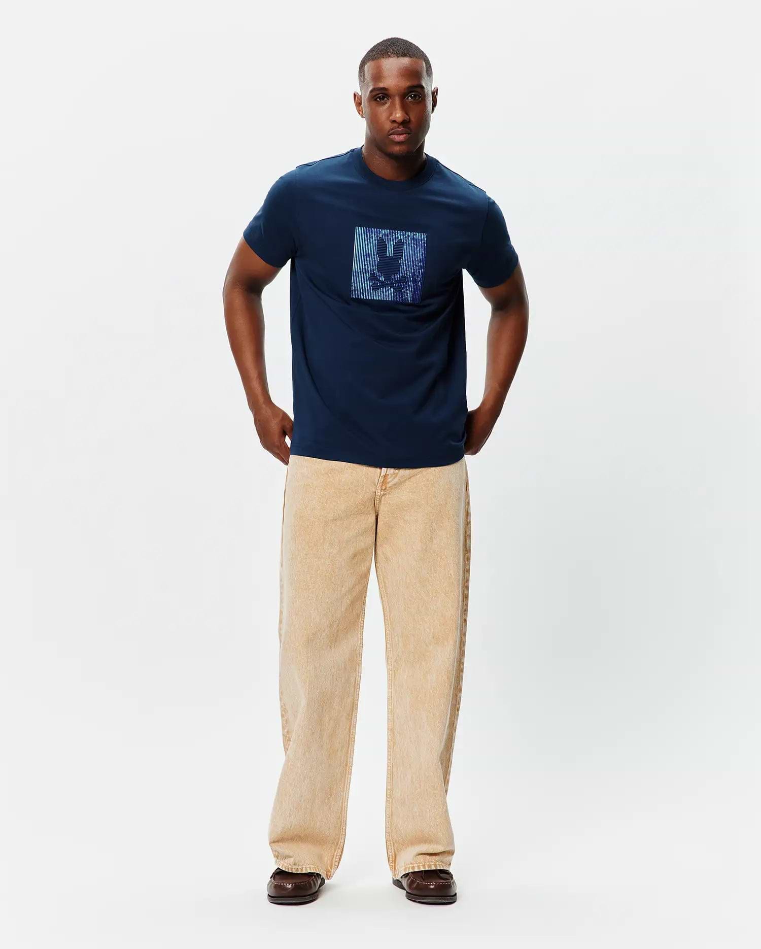 Mens Seamus Graphic Tee, a classic fit navy blue jersey t-shirt featuring a large, centered, iridescent blue and purple pixelated Psycho Bunny skull logo graphic on the chest.